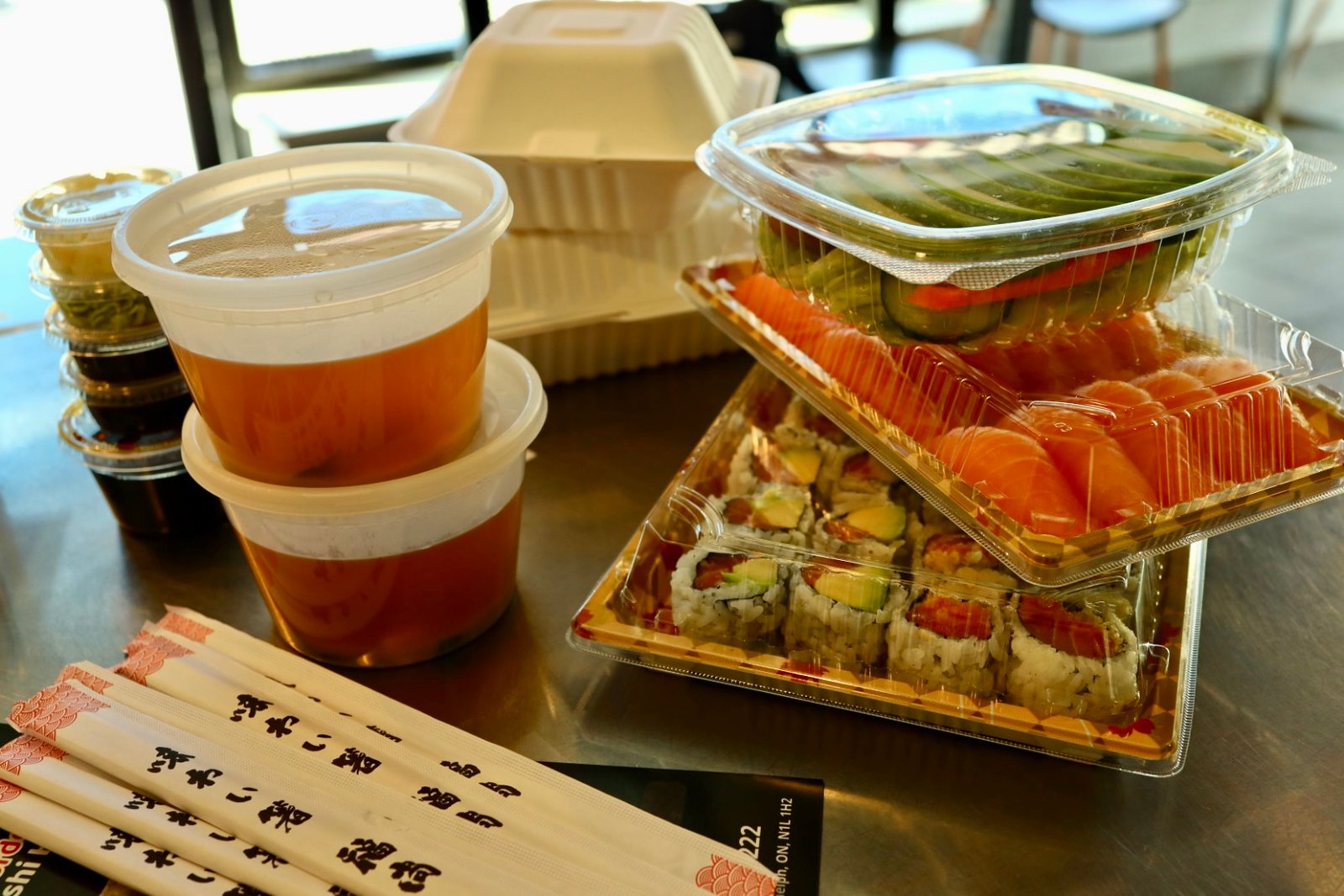 Complete order with avocado salad, two boxes of sushi, 2 miso soups, appetizers, and sides.